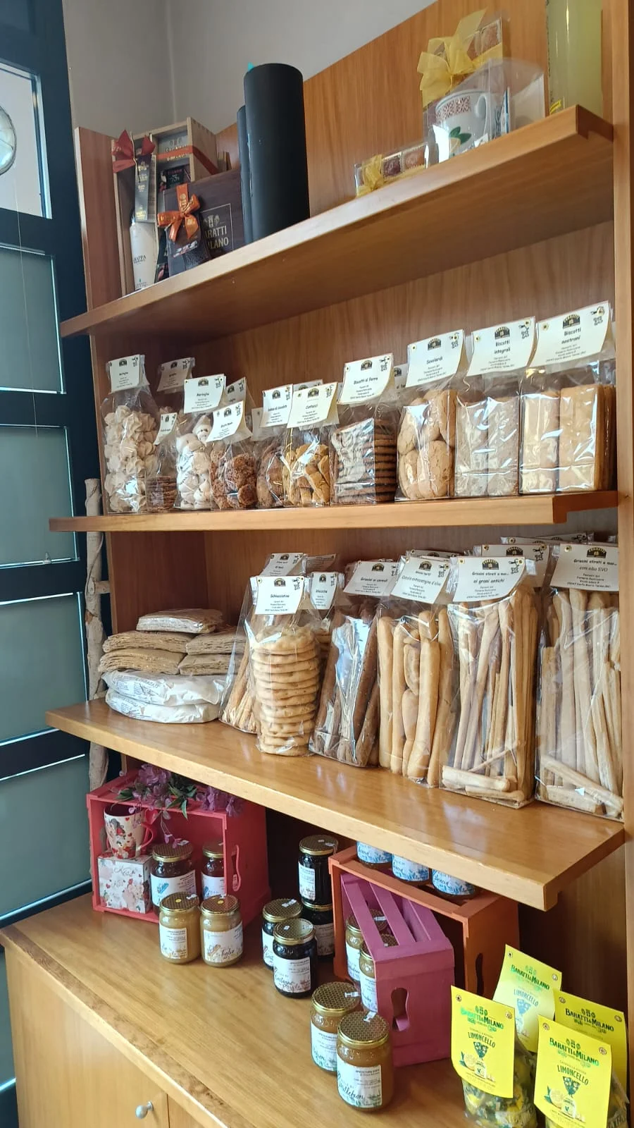 Scaffale con biscotti, grissini, miele e marmellate Scaffale con biscotti, grissini, miele e marmellate